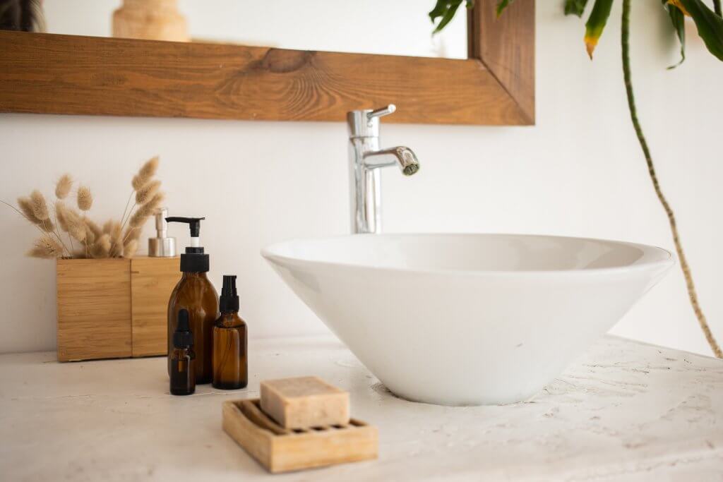 stylish bathroom sink next to amber glass bottles and natural soap